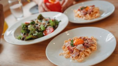 delicious pasta and salad on table