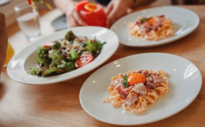 delicious pasta and salad on table